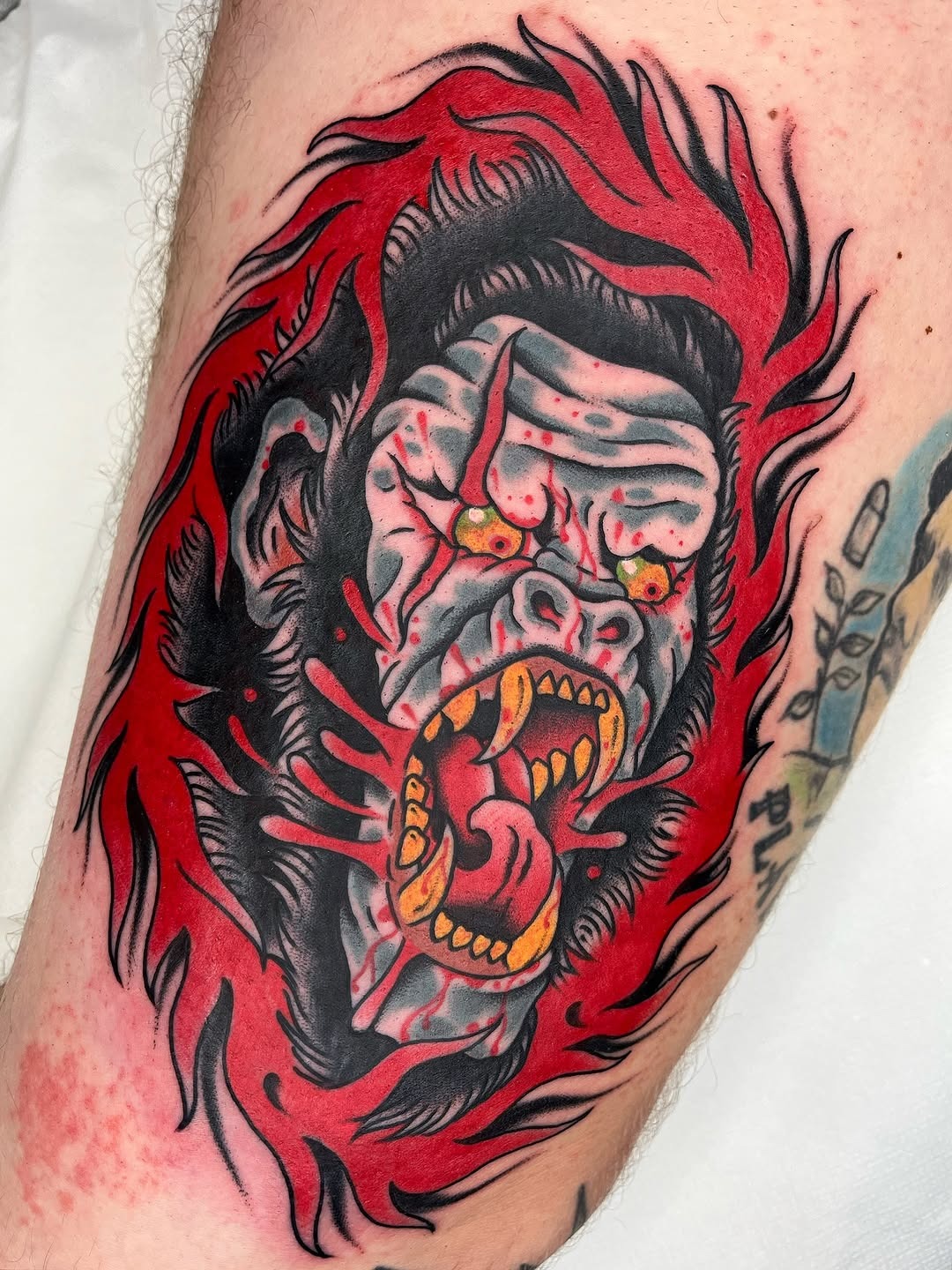 This tattoo depicts a fierce gorilla with a striking color palette.