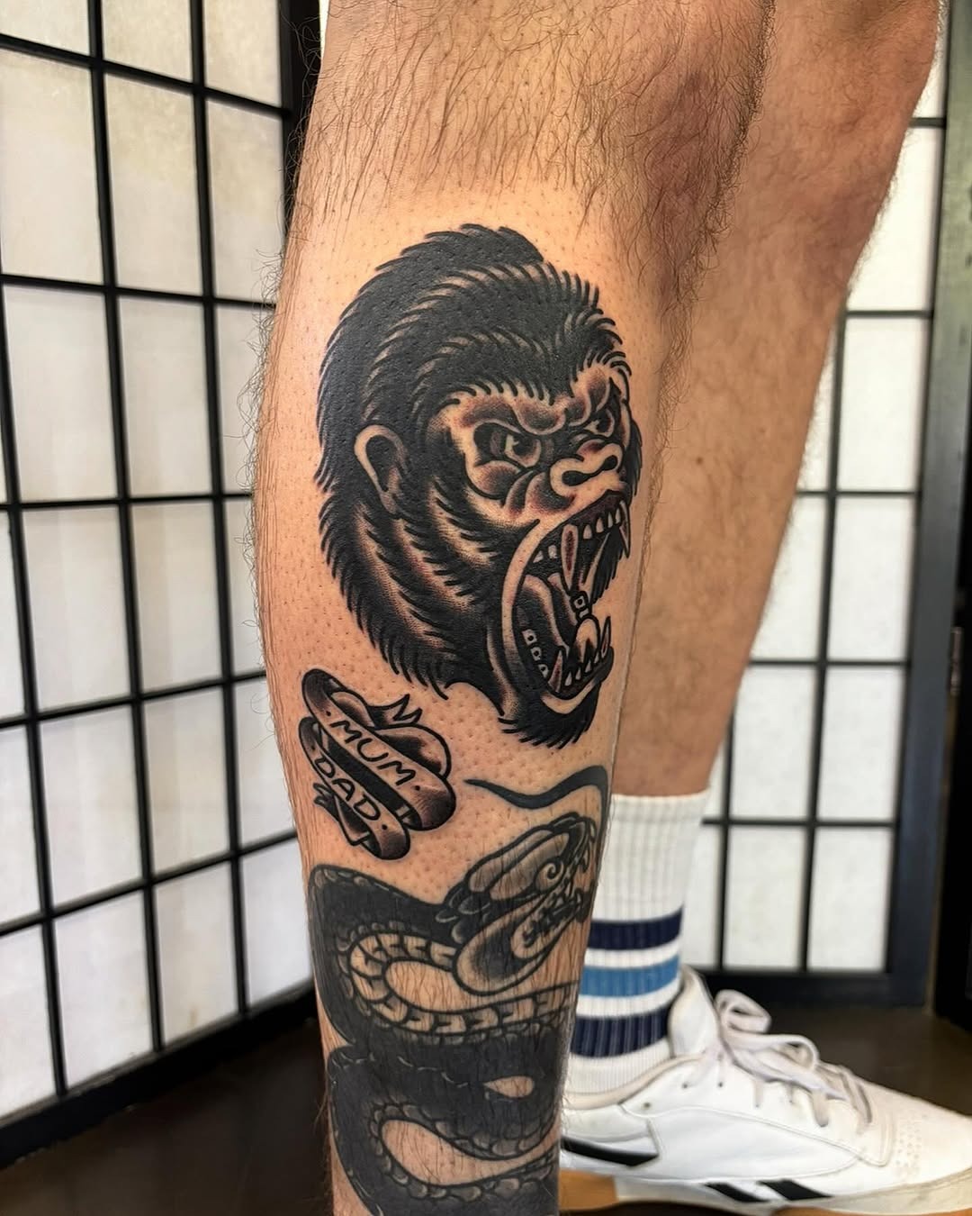 This striking tattoo features a roaring gorilla's face, capturing its raw power and intensity.