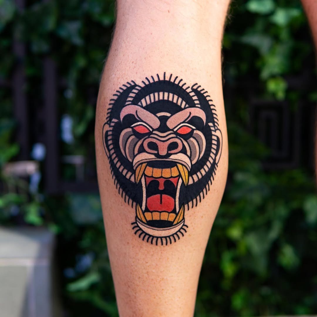 This tattoo showcases a detailed and fierce gorilla face.