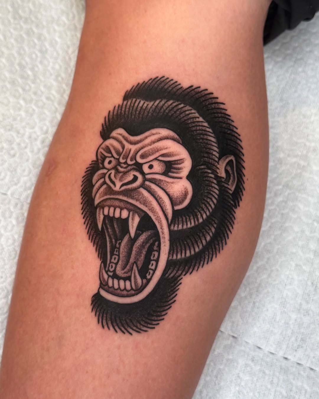 This striking gorilla tattoo showcases a fierce expression and intricate detail.