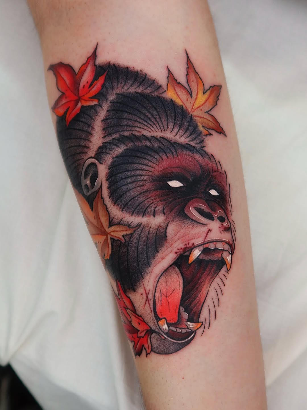 This tattoo showcases a powerful gorilla face, featuring striking details and bold colors.