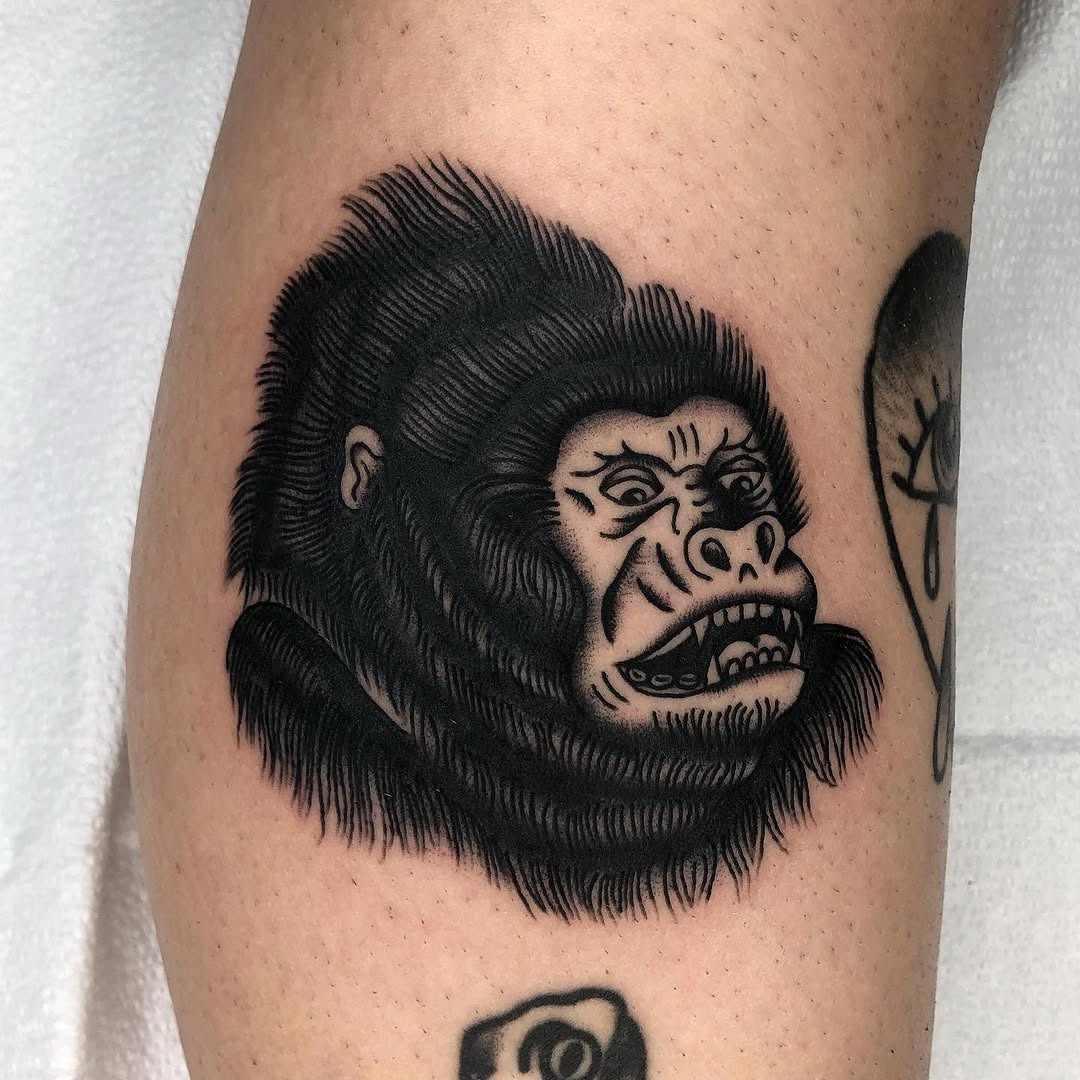 This bold gorilla tattoo showcases stunning detail, emphasizing the creature's fierce expression.