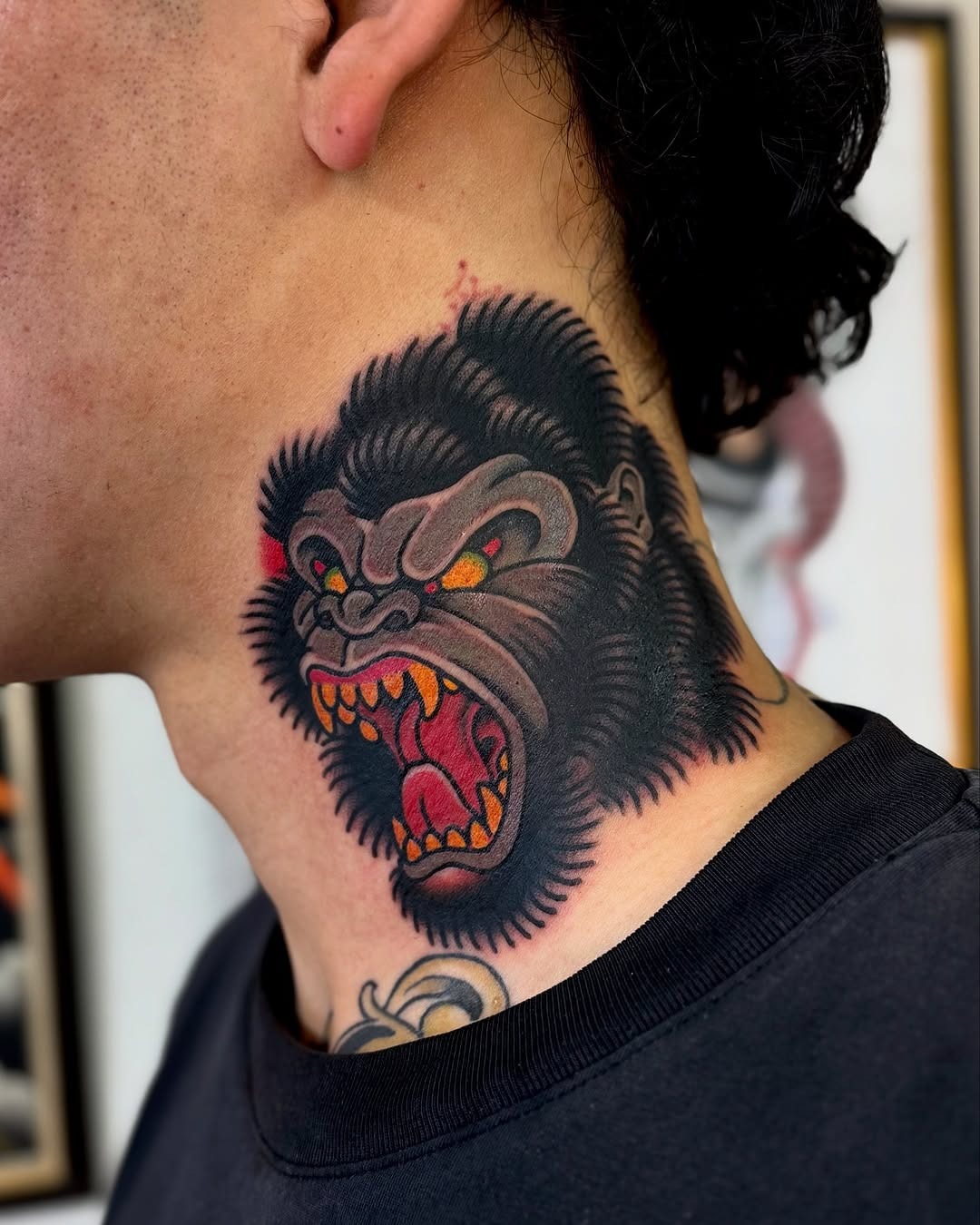 This fierce gorilla tattoo features a dramatic design, showing a roaring head with colors and intense details.