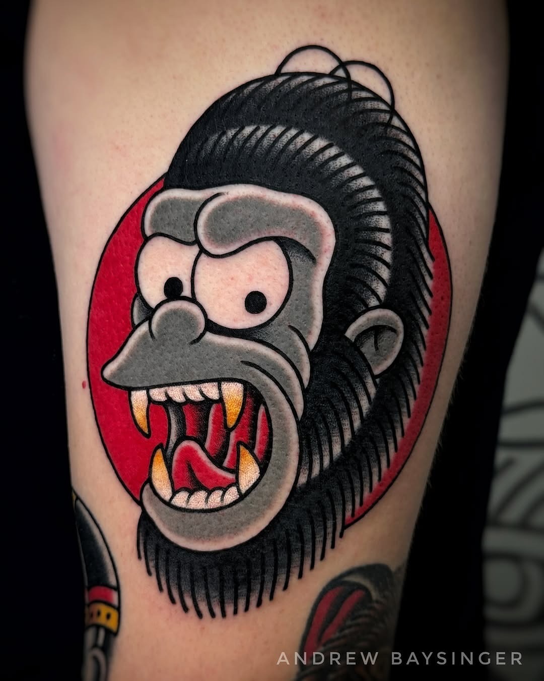 This tattoo features a striking comic-style gorilla face with exaggerated expressions and colors.