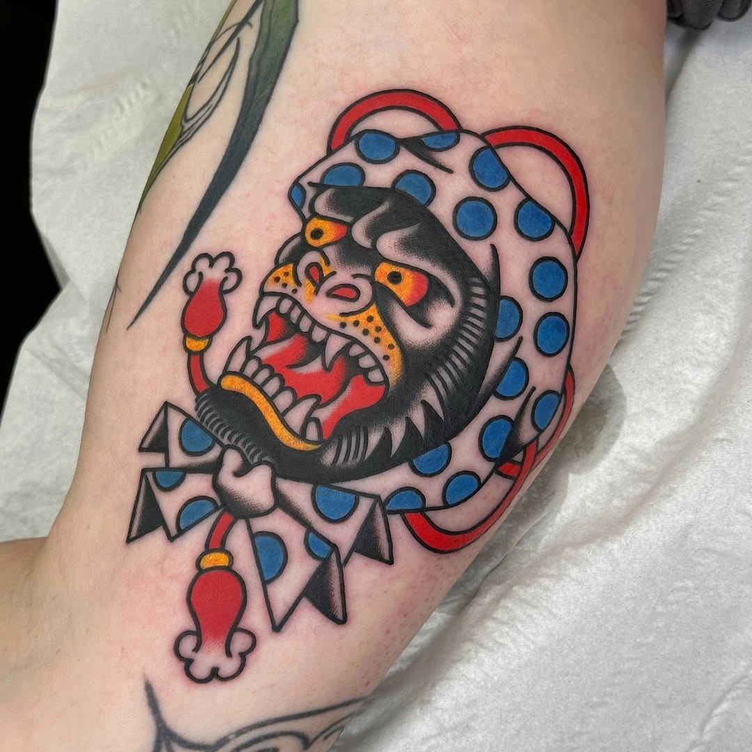 This playful gorilla tattoo features bold colors and dynamic lines.