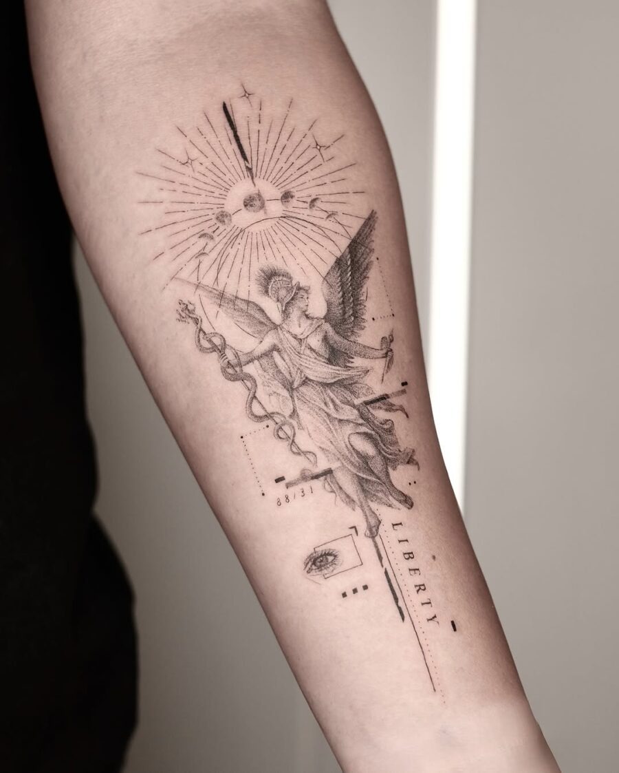 This tattoo beautifully showcases the figure of Liberty, adorned with celestial motifs like rays of light and an eye symbol.