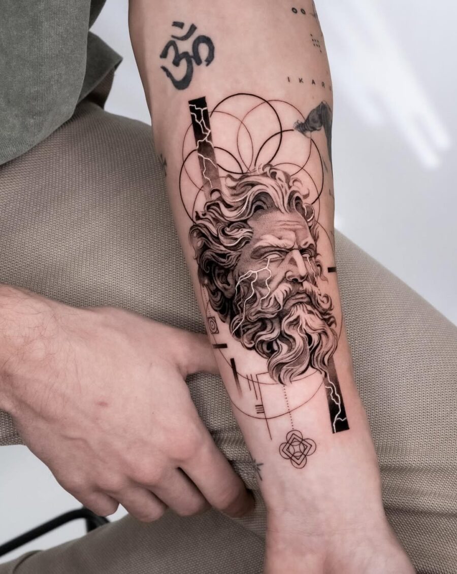 This tattoo features a striking depiction of Zeus, showing his powerful visage and flowing beard.