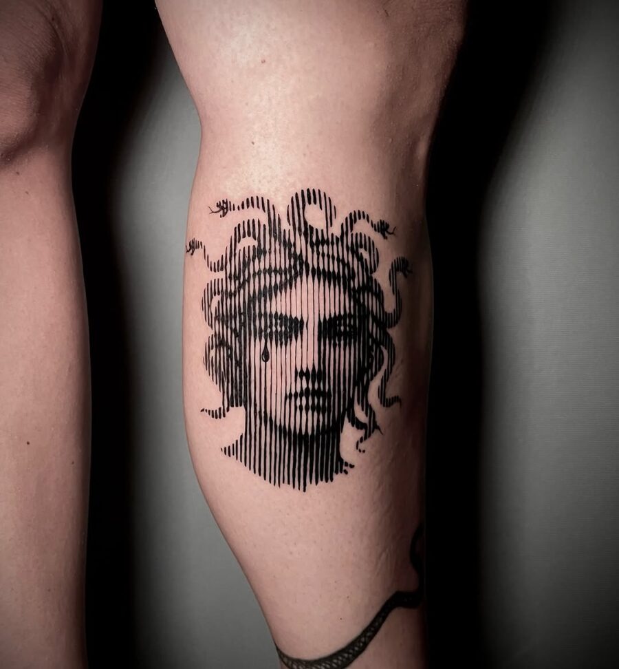 This tattoo features a stunning rendition of Medusa with intricate lines and snake details.