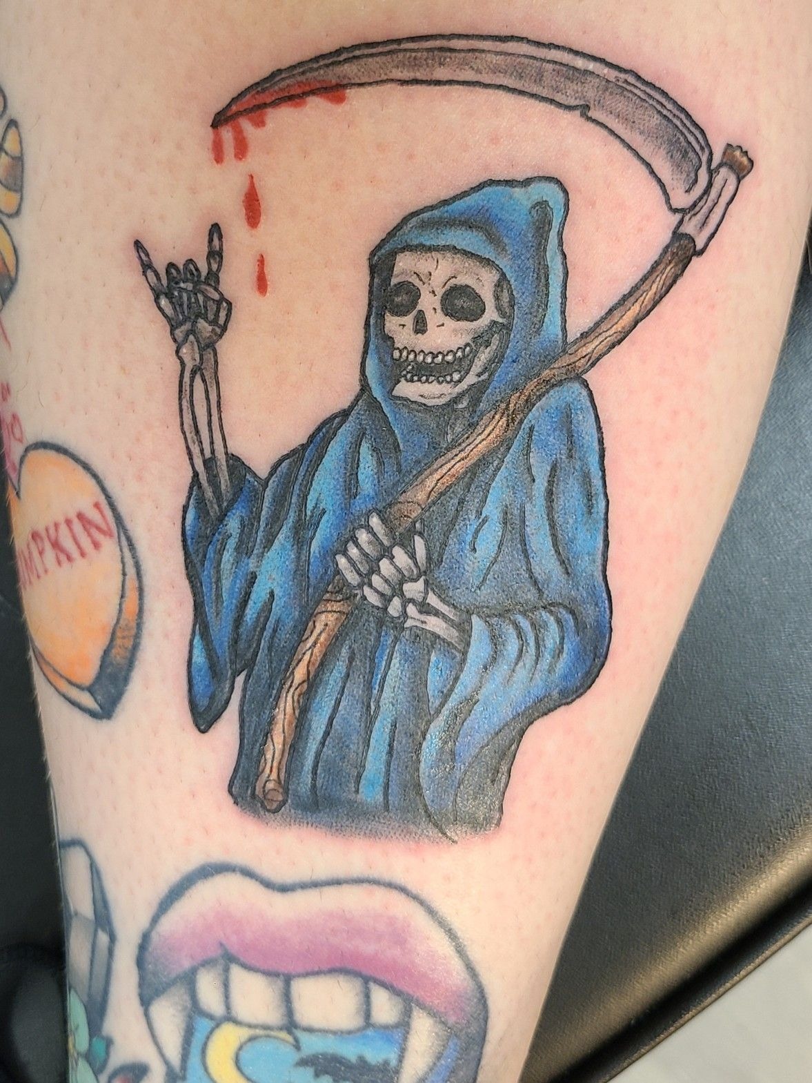 Blue Cloaked Reaper With Rock-Hand Gesture, a tattoo design rendered in bold.