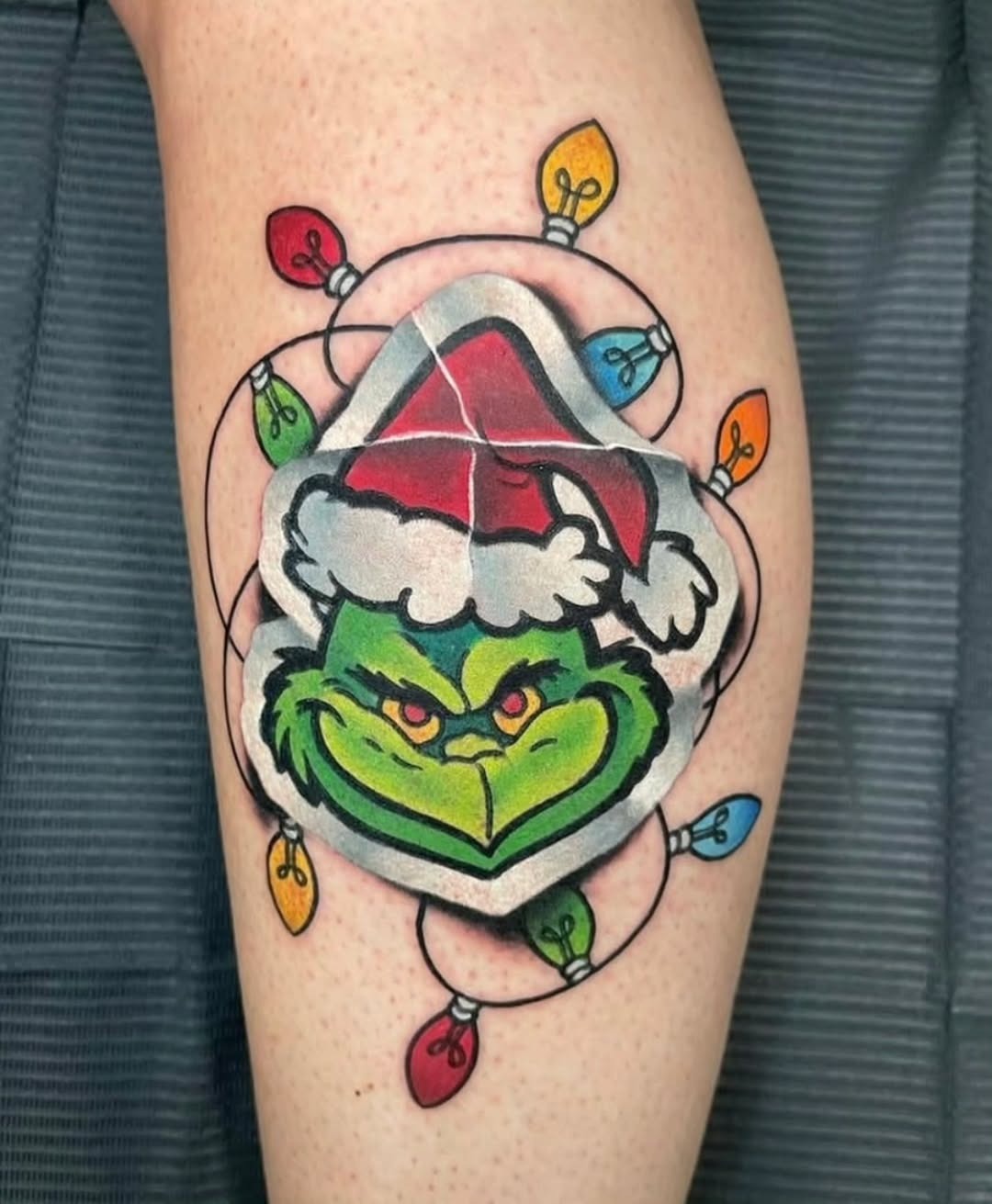 Playful Grinch Tattoo Surrounded by Colorful Lights Tattoo Design