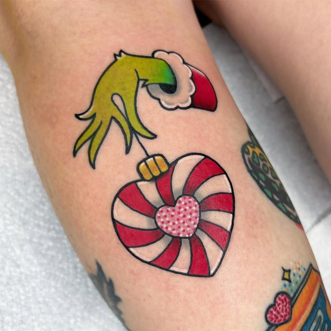 Whimsical Grinch Grabbing a Candy Heart Tattoo Design