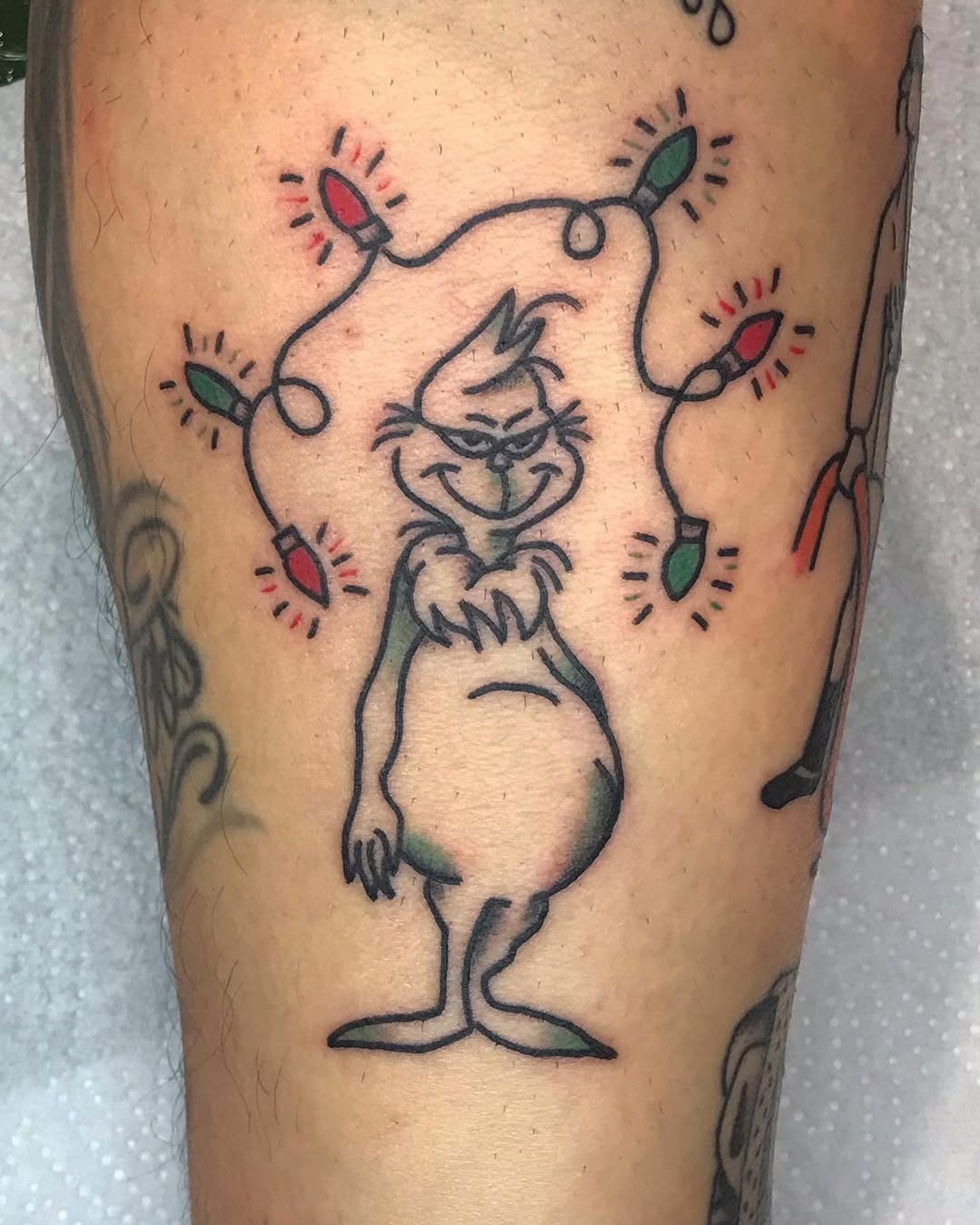 Whimsical Grinch Tattoo with Christmas Lights Tattoo Design