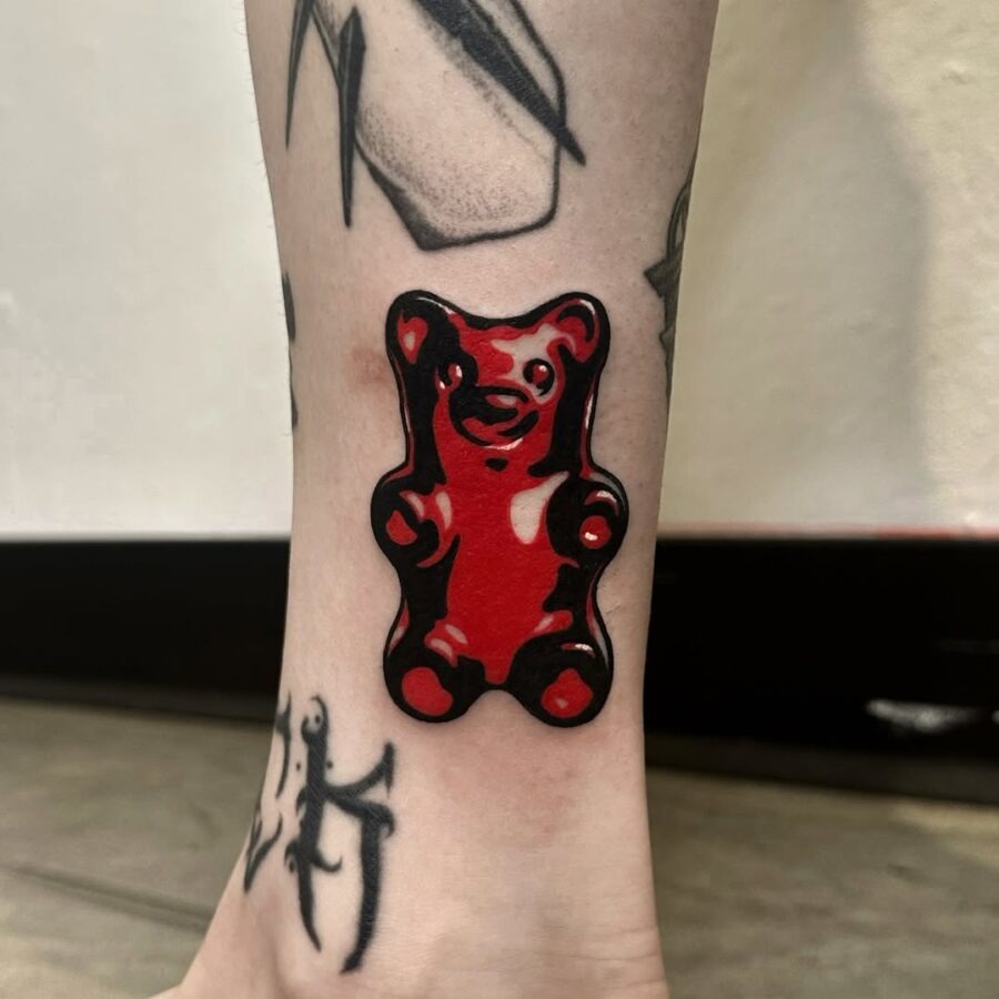 Vibrant red gummy bear tattoo on ankle Tattoo Design