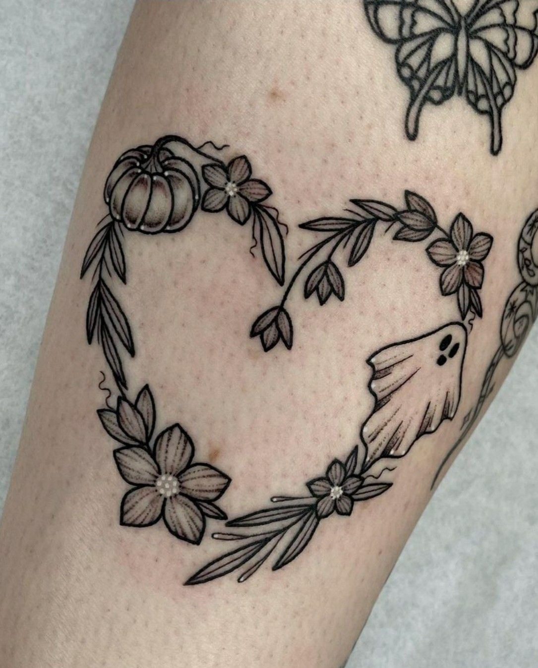 Heart-Shaped Halloween Wreath, a tattoo design rendered in delicate fine-line.