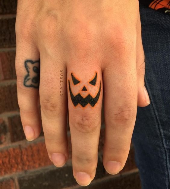Pumpkin Face Finger Tattoo, a tattoo design rendered in bold.