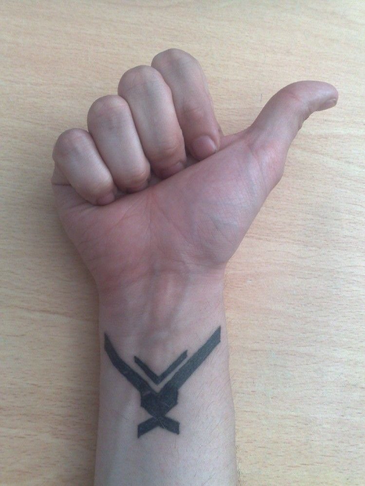 Subtle Emblem Wrist Mark Tattoo Design