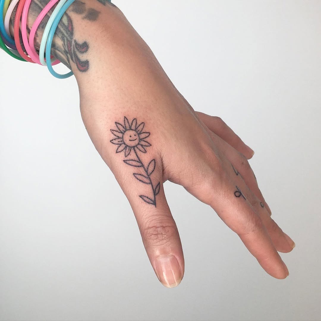 Charming smiling flower tattoo on hand Tattoo Design