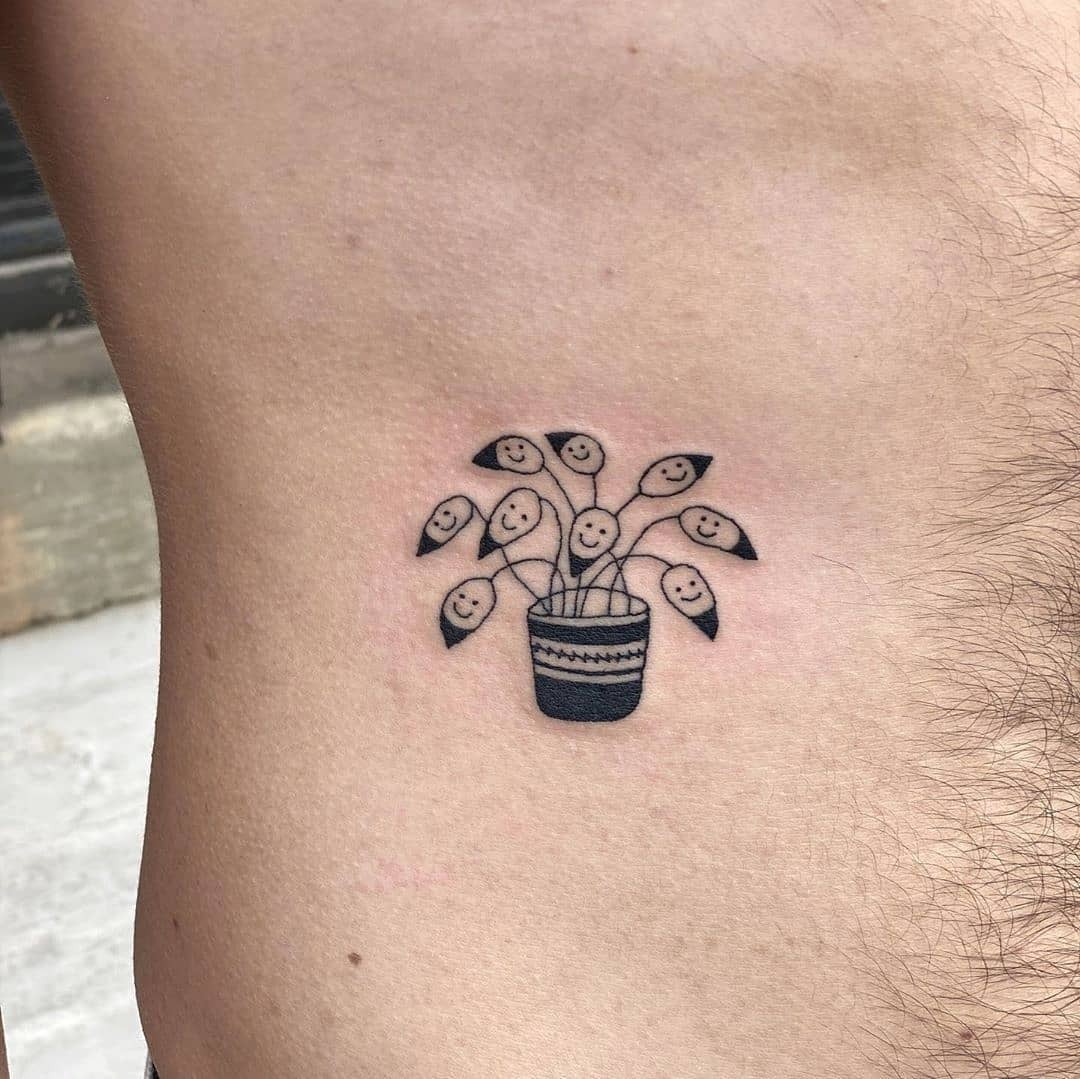 Whimsical plant with joyful faces tattoo Tattoo Design
