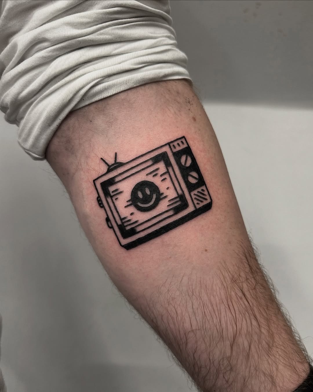 Whimsical TV Tattoo with a Smiley Face Tattoo Design