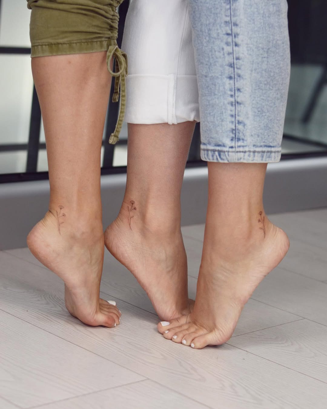 Delicate floral tattoos on sister's ankles Tattoo Design