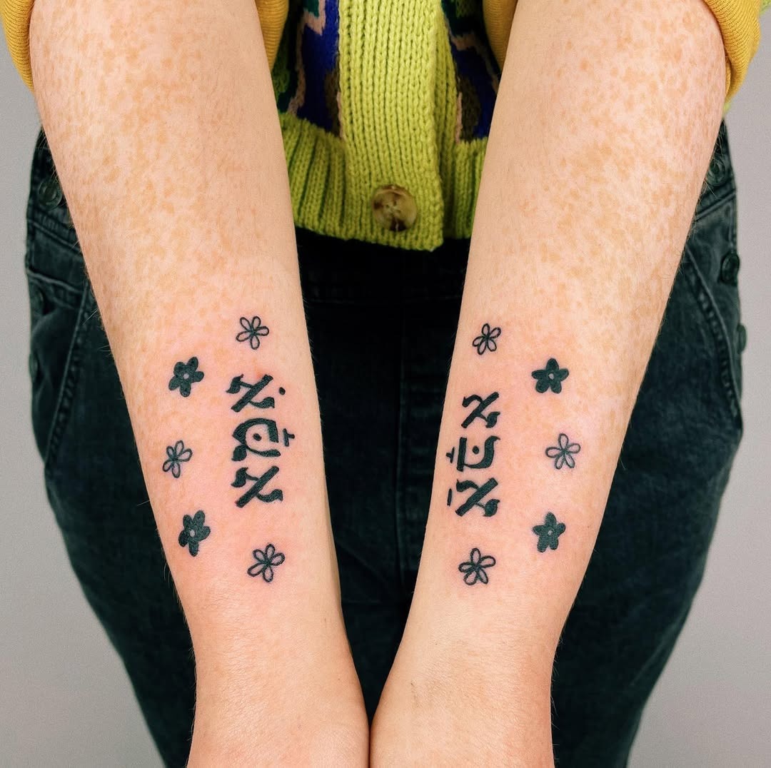 Delicate Hebrew Tattoos with Flower Accents Tattoo Design