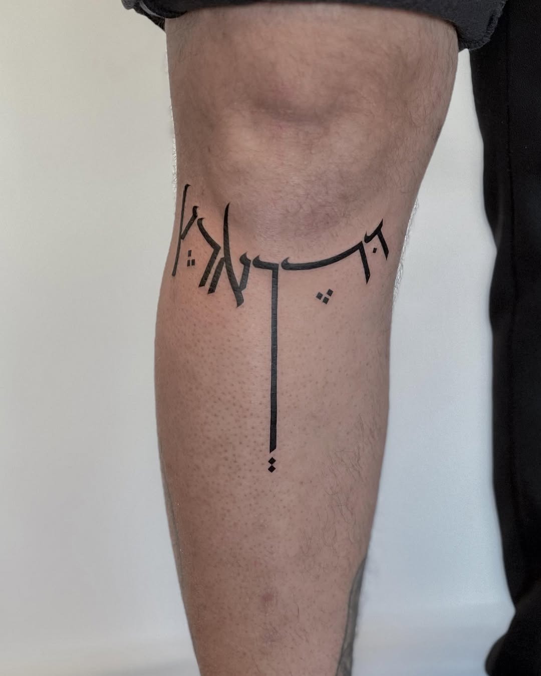 Elegant Hebrew Script Tattoo on the Leg Tattoo Design