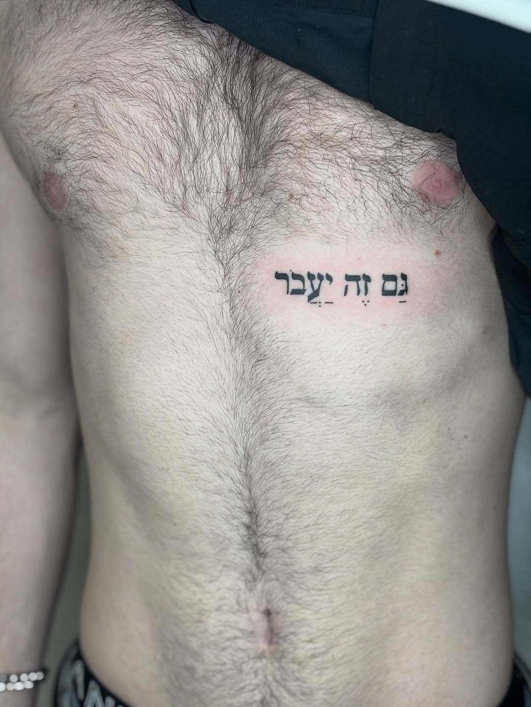 Expressive Hebrew script tattoo on the chest Tattoo Design