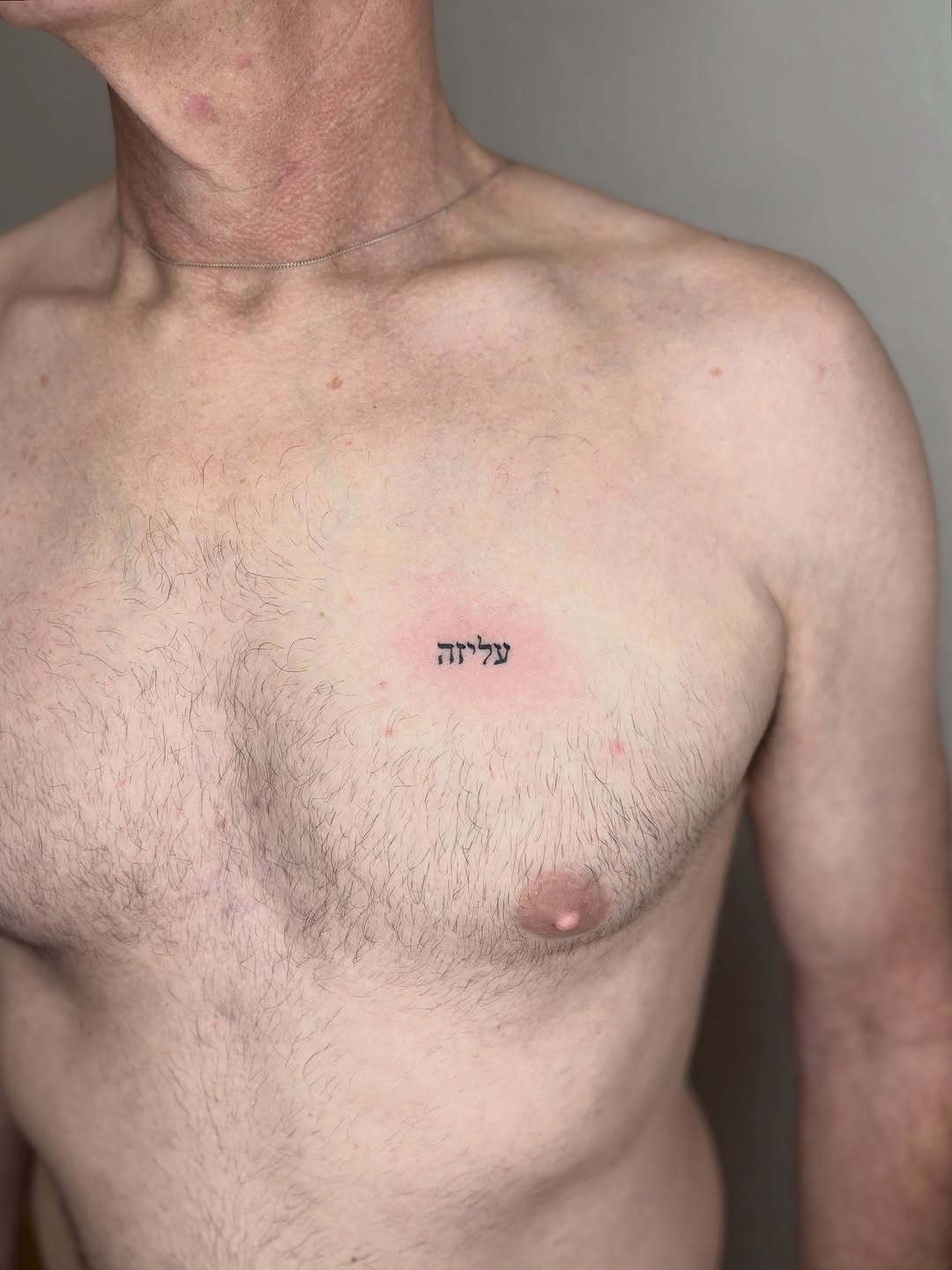 Meaningful Hebrew Tattoo on Upper Chest Tattoo Design