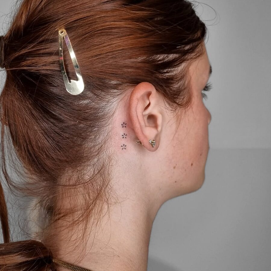 Delicate floral tattoo discreetly placed behind ear Tattoo Design