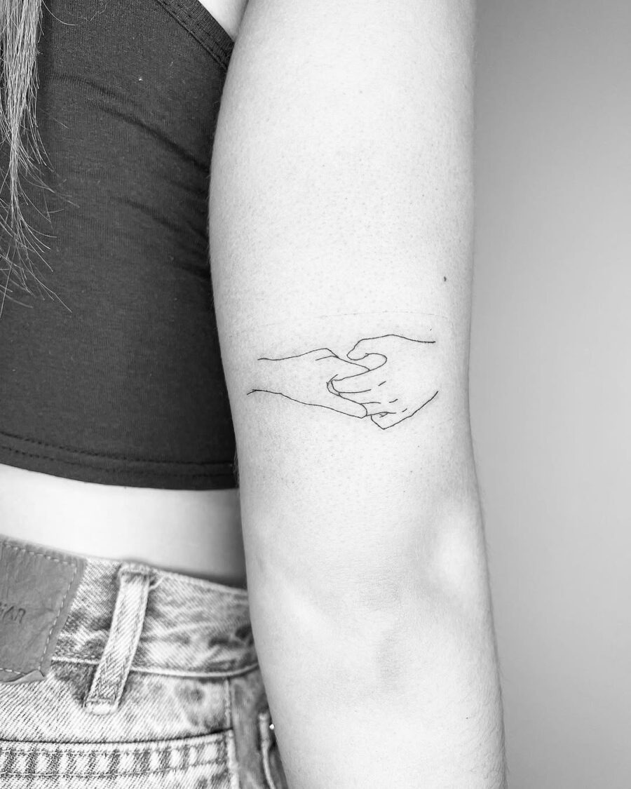 Elegant minimalist tattoo of intertwined hands Tattoo Design