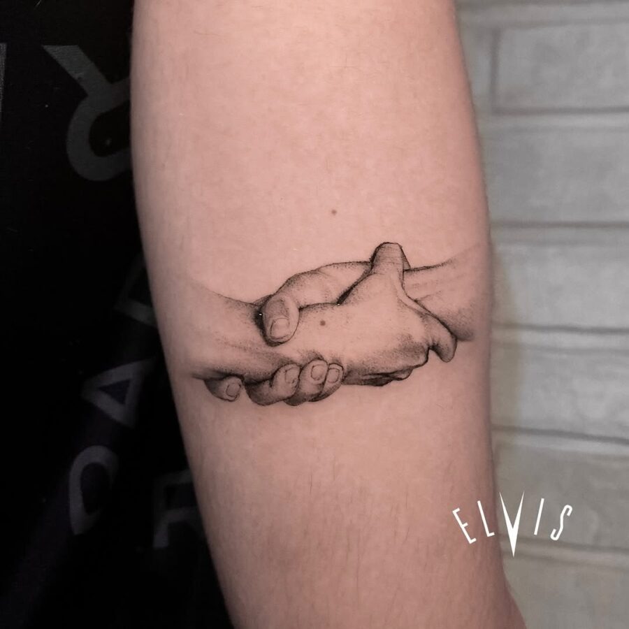 Realistic tattoo of hands clasped together Tattoo Design