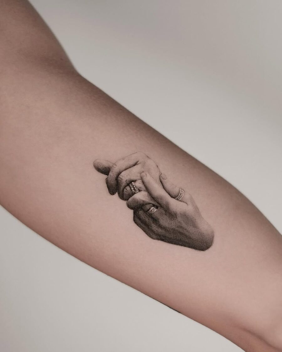 Realistic tattoo of intertwined hands with rings Tattoo Design