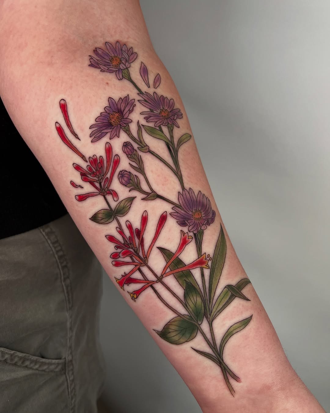 This honeysuckle tattoo beautifully combines delicate hues and intricate details.