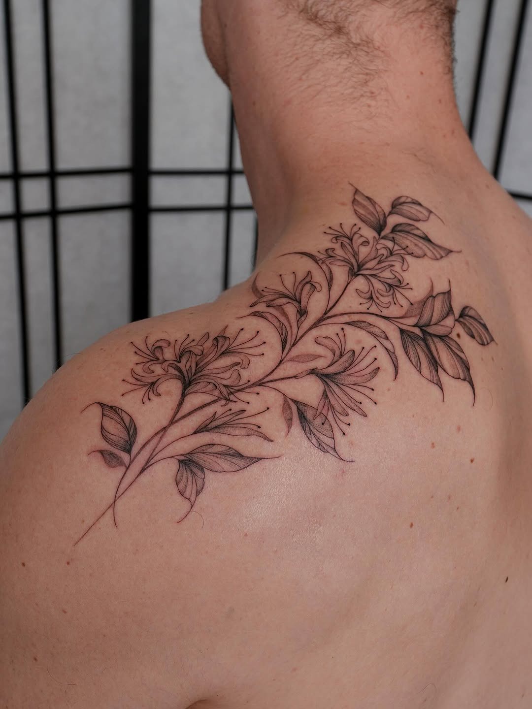 This beautiful honeysuckle tattoo features intricate floral details and flowing leaves, creating a natural and organic vibe.