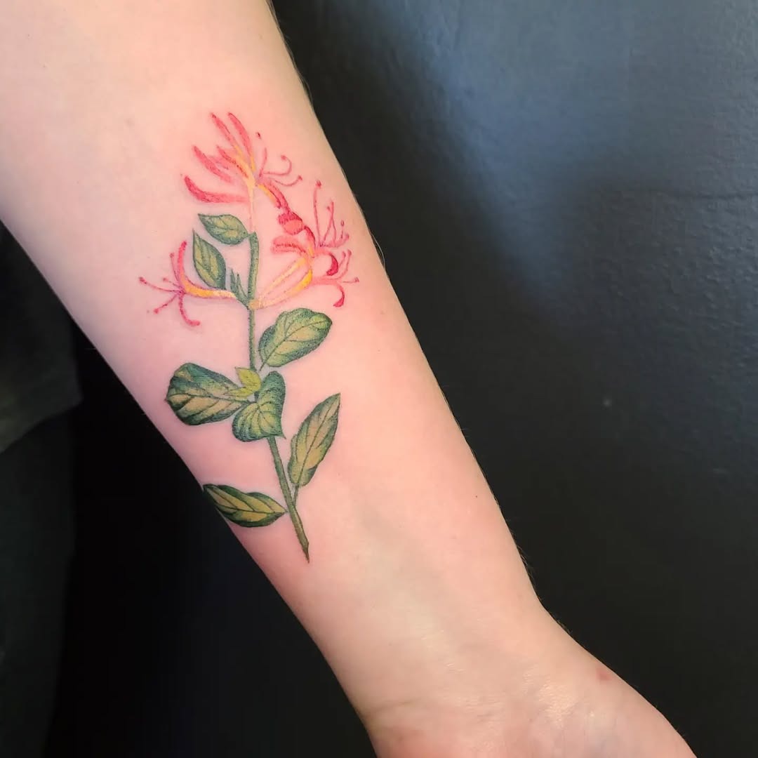 This honeysuckle tattoo showcases intricate details with bright colors that pop against the skin.
