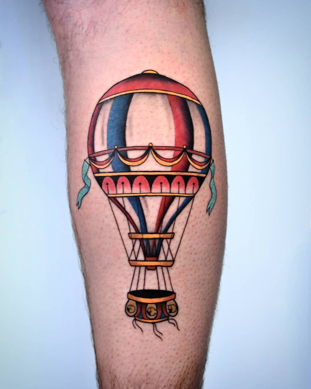 This hot air balloon tattoo features bright colors and intricate details, showing a whimsical design.
