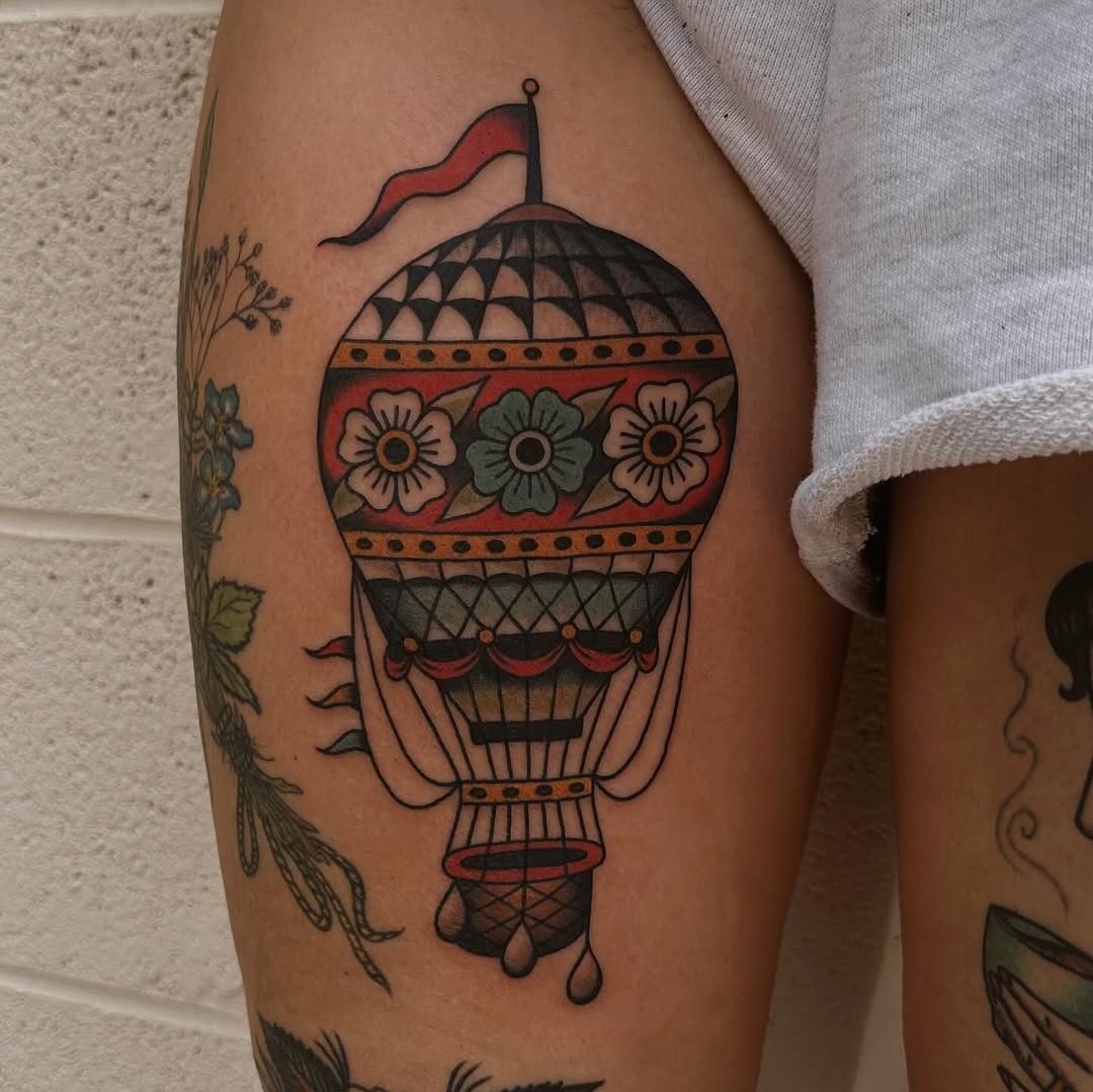 This hot air balloon tattoo showcases intricate designs and a lively color palette.