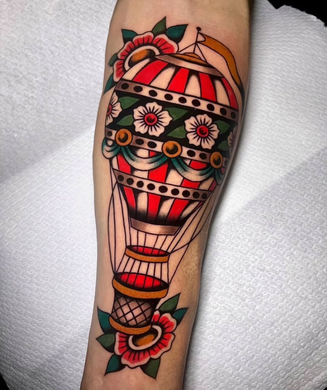 This hot air balloon tattoo features bold colors and intricate floral designs.