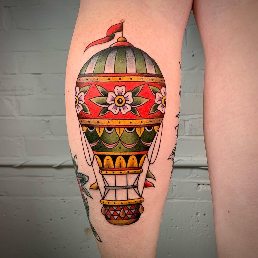 This hot air balloon tattoo features intricate floral designs that add a whimsical touch.