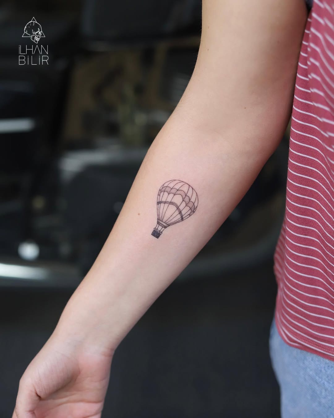 This minimalist hot air balloon tattoo features a delicate outline, giving it an elegant vibe.
