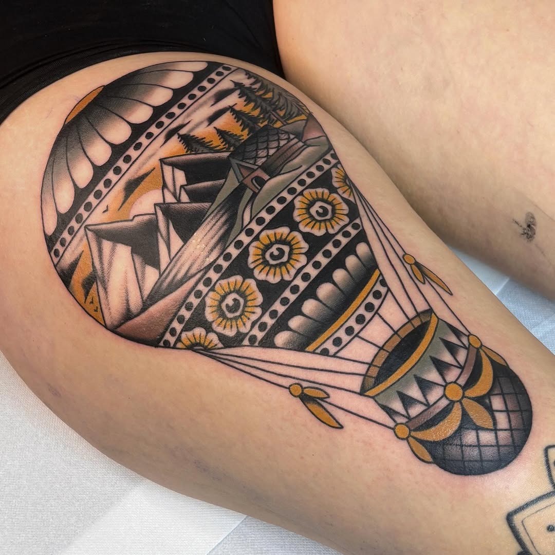 This tattoo showcases an intricate hot air balloon with detailed patterns and bold lines.