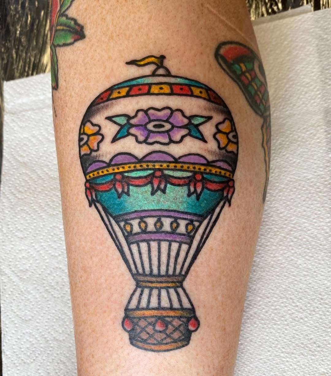 This colorful hot air balloon tattoo features intricate floral patterns and lively details.