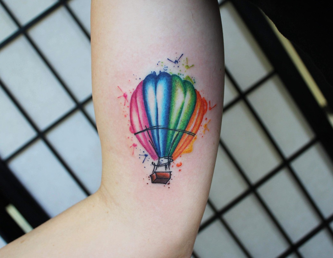 This lively hot air balloon tattoo features an array of bright colors, capturing the essence of freedom and adventure.