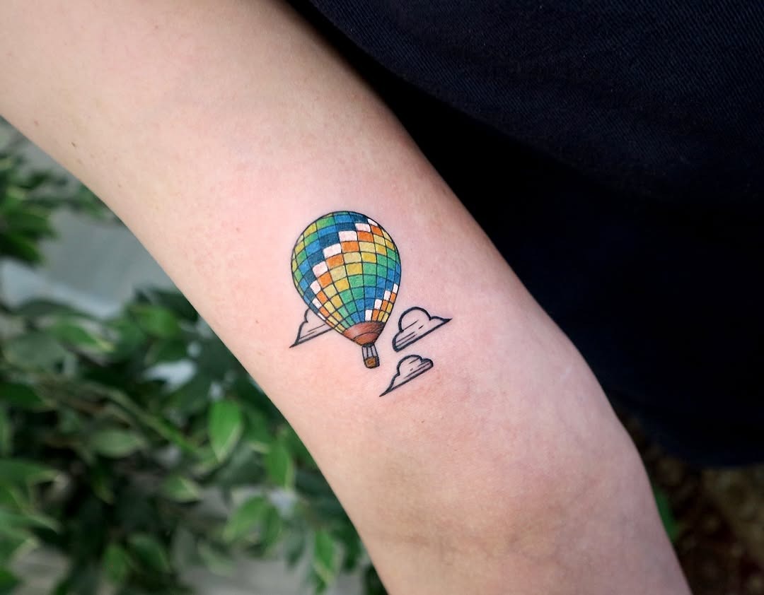 This charming hot air balloon tattoo bursts with color and playful energy.
