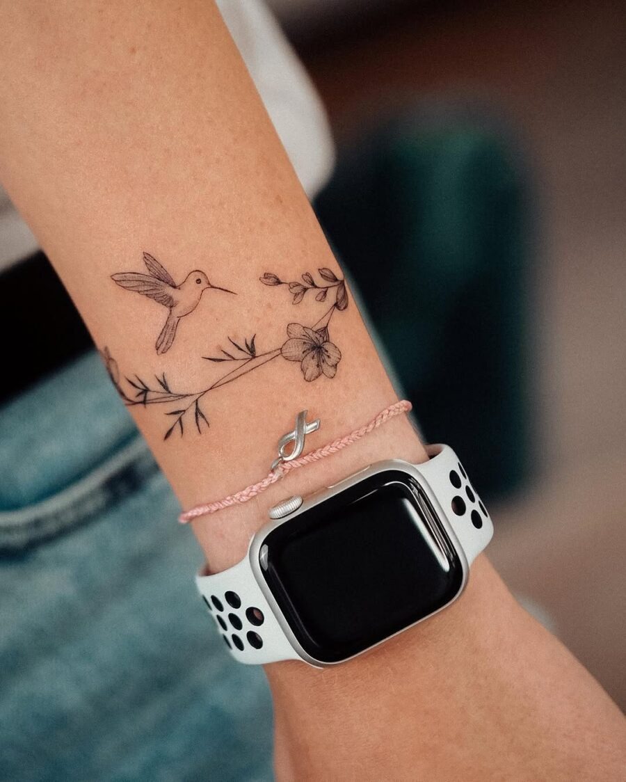 Delicate hummingbird tattoo adorned with flowers Tattoo Design
