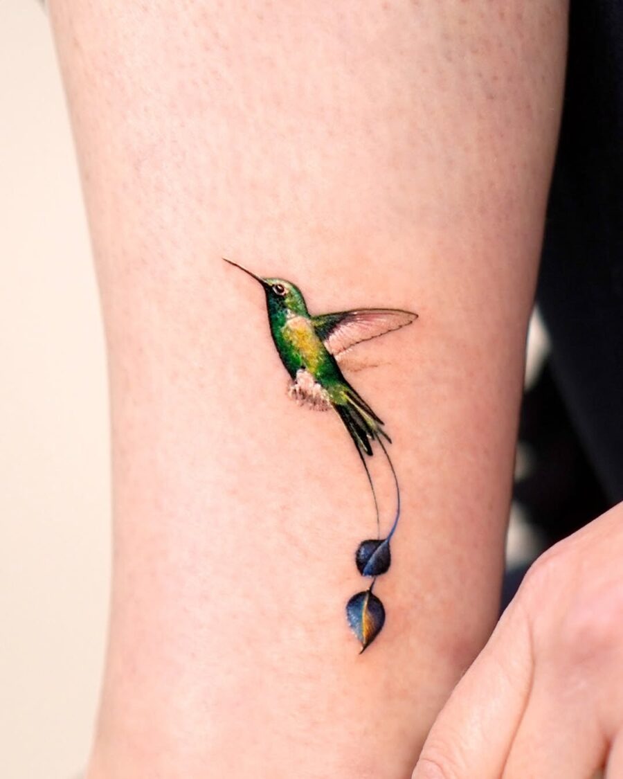 Elegant hummingbird tattoo with floral accents Tattoo Design