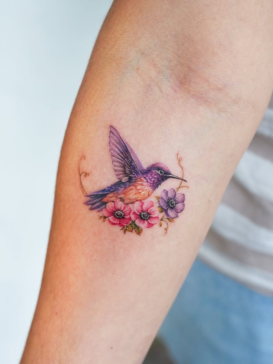 Elegant hummingbird tattoo with floral elements Tattoo Design