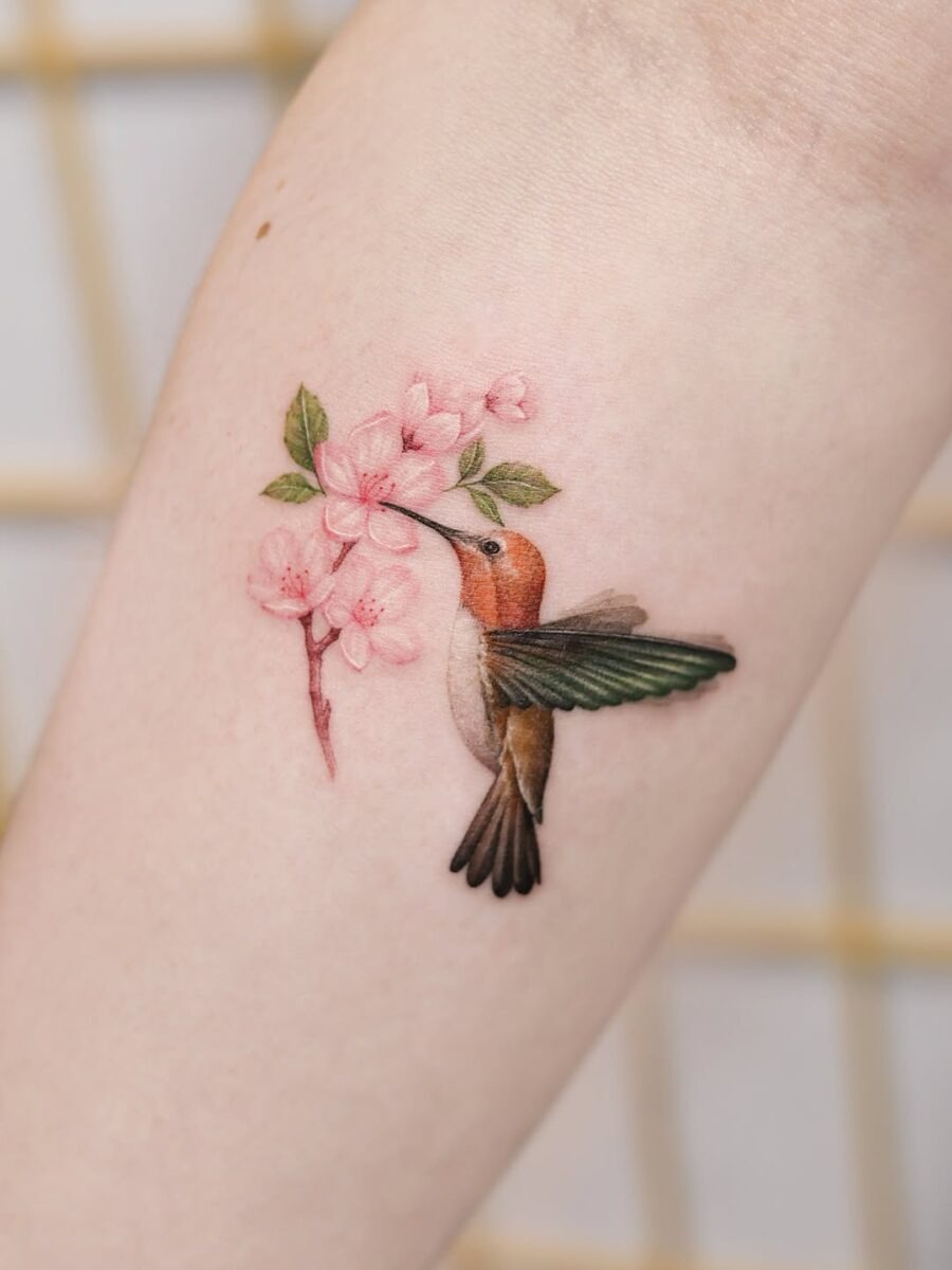 Graceful hummingbird tattoo amongst delicate blossoms Tattoo Design