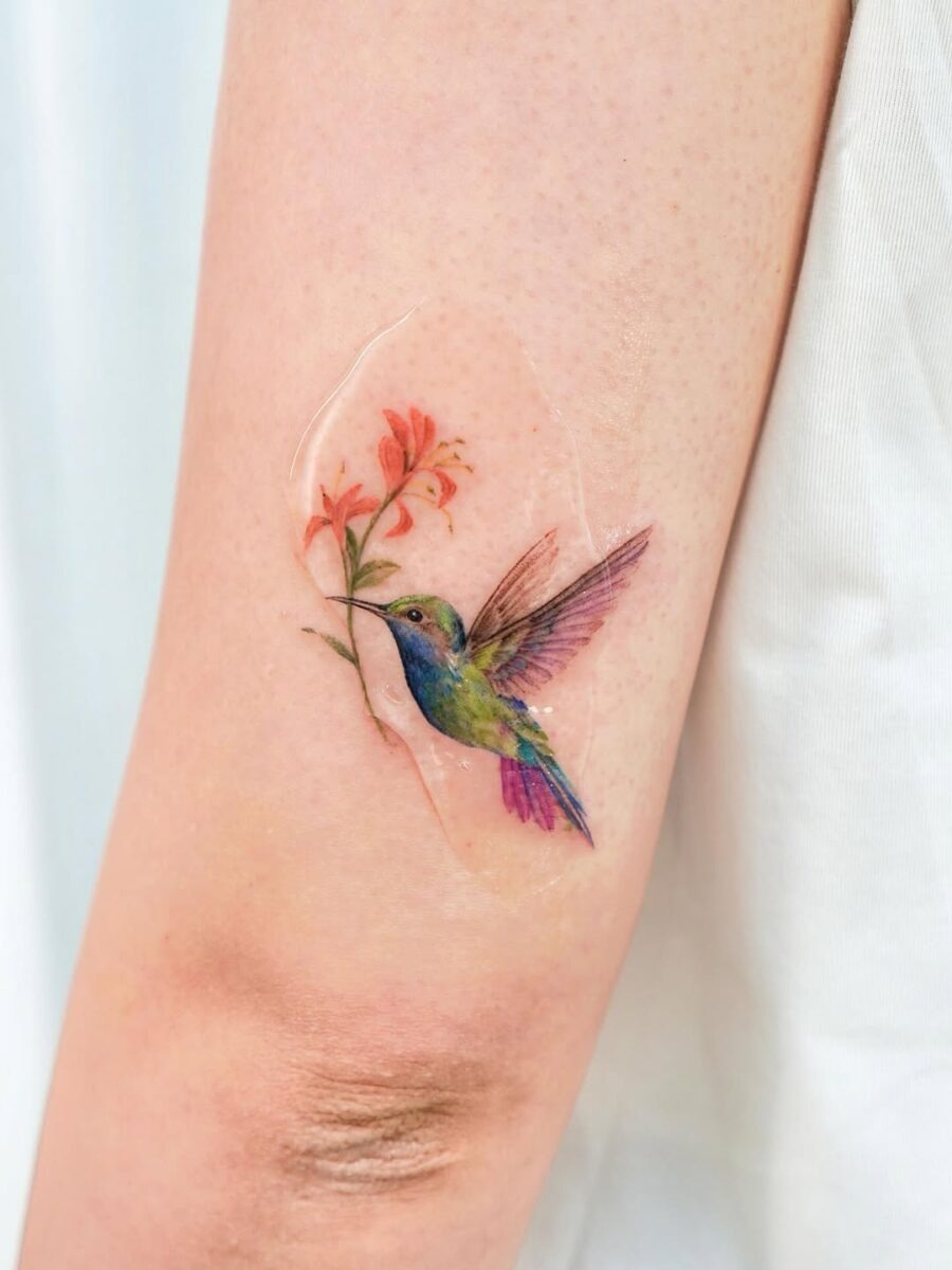 Vibrant hummingbird tattoo with floral design Tattoo Design