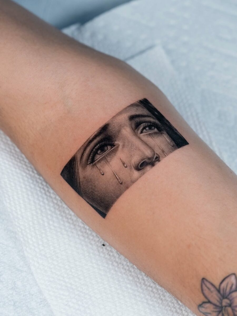 Expressive face tattoo with realistic tears Tattoo Design